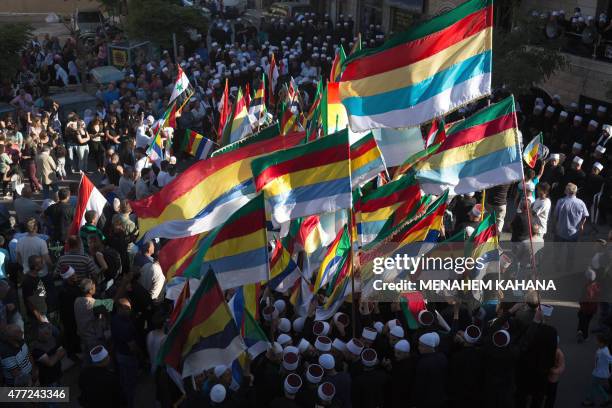 Members of the Druze community of the Israeli-annexed Golan Heights wave their community's flag during a demonstration in the Druze village of Majdal...