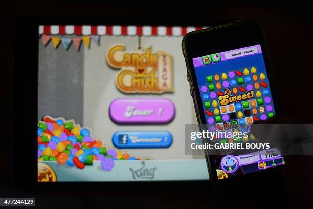 In this file picture taken on January 25, 2014 a man plays at Candy Crush Saga on his Iphone in Rome. Candy Crush is one of the top online games...