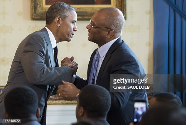 President Barack Obama embraces Broderick Johnson, Cabinet Secretary and Chair of the My Brother's Keeper Task Force, during the White House...