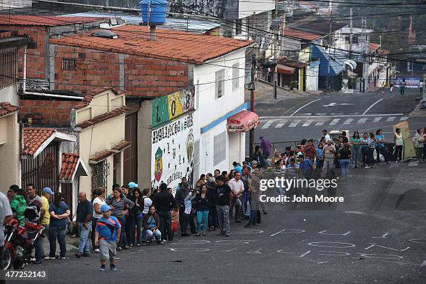 Long que of people queue up before sunrise to buy basic foodstuffs at a supermarket on March 8, 2014 in San Cristobal, the capital of Tachira state,...