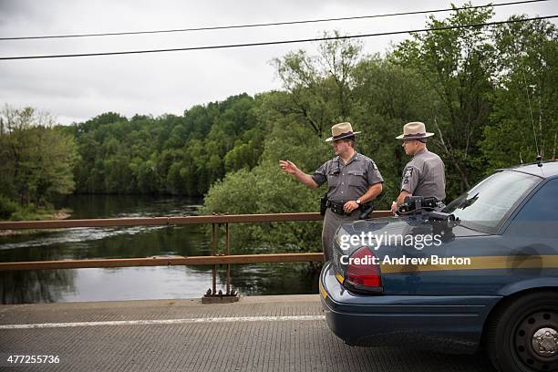 New York State Troopers hold a meeting while searching for two escaped convicts on June 15, 2015 outside Dannemora, New York. The two convicted...