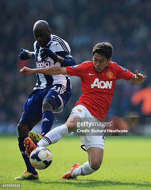 Shinji Kagawa of Manchester United tackles Youssuf Mulumbu of West Bromwich Albion during the Barclays Premier League match between West Bromwich...