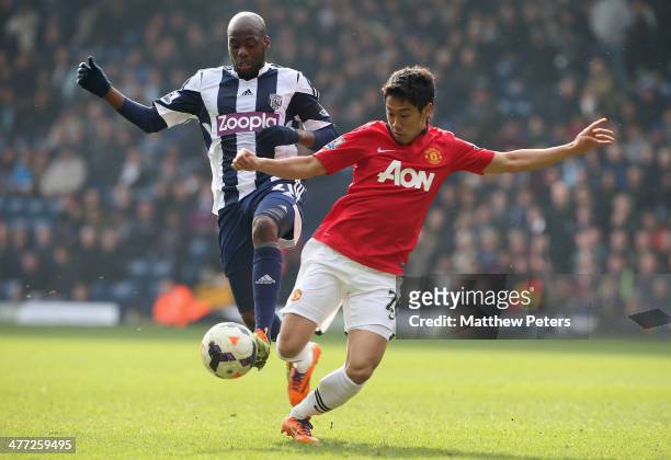 Shinji Kagawa of Manchester United in action with Youssouf Mulumbu of West Bromwich Albion during the Barclays Premier League match between West...