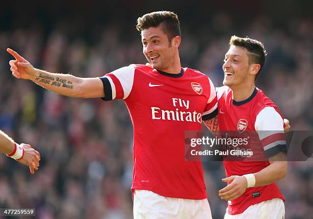 Olivier Giroud of Arsenal celebrates with teammate Mesut Oezil after scoring his team's fourth goal during the FA Cup Quarter-Final match between...