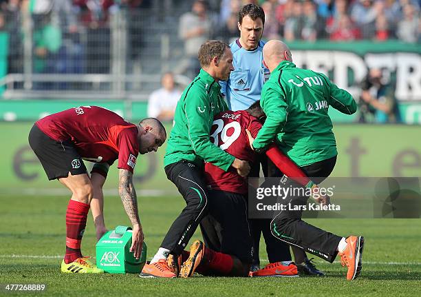 Mame Diouf of Hanover leaves the pitch injured after being hit in attack during the Bundesliga match between Hannover 96 and Bayer Leverkusen at...