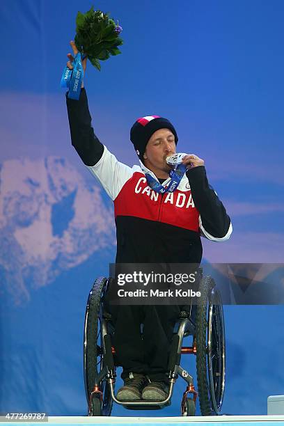 Bronze medalist Josh Dueck of Canada kisses hi medal at the medal ceremony for the Men's Downhill Sitting during day one of Sochi 2014 Paralympic...