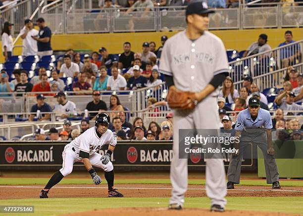 Ichiro Suzuki of the Miami Marlins leads off first base as Masahiro Tanaka of the New York Yankees sets to pitch during the first inning of the game...