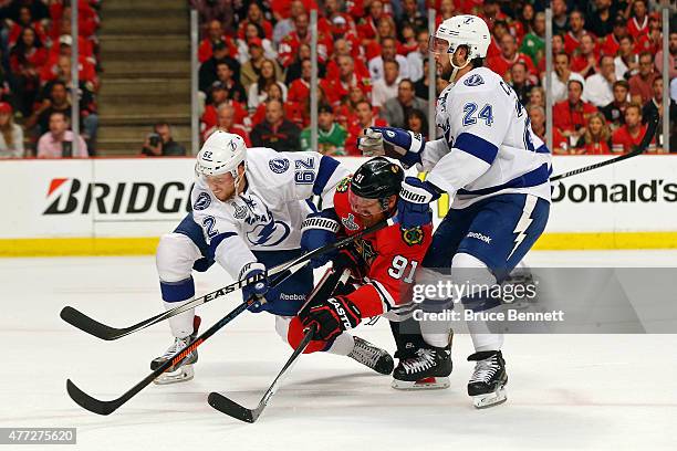 Brad Richards of the Chicago Blackhawks fights for the puck against Andrej Sustr and Ryan Callahan of the Tampa Bay Lightning during Game Six of the...