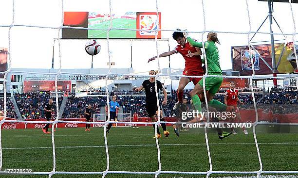 China's defender Wang Sanshan heads the ball to score a goal past New Zealand's goalkeeper Erin Nayler during their Group A football match of the...