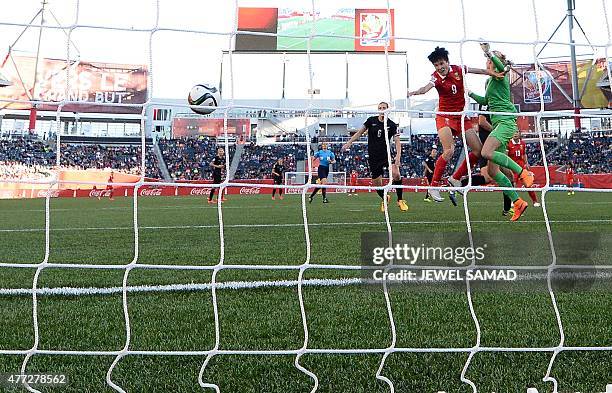 China's defender Wang Sanshan heads the ball to score a goal past New Zealand's goalkeeper Erin Nayler during their Group A football match of the...