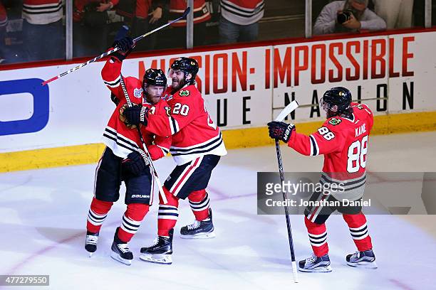 Duncan Keith of the Chicago Blackhawks celebrates with teammate Brandon Saad and Patrick Kane after scoring a goal in the second period against Ben...