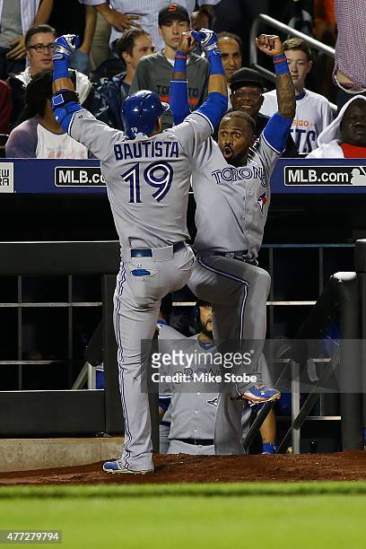 Jose Bautista of the Toronto Blue Jays celebrates with Jose Reyes after hitting a game-tying home run in the ninth inning against the New York Mets...