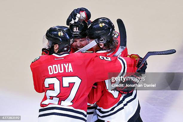 Patrick Kane of the Chicago Blackhawks celebrates with teammates Johnny Oduya and Brad Richards after scoring a goal in the third period against the...