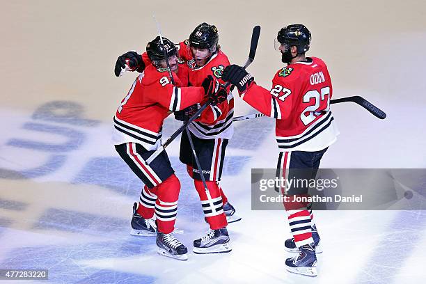 Patrick Kane of the Chicago Blackhawks celebrates with teammates Johnny Oduya and Brad Richards after scoring a goal in the third period against the...