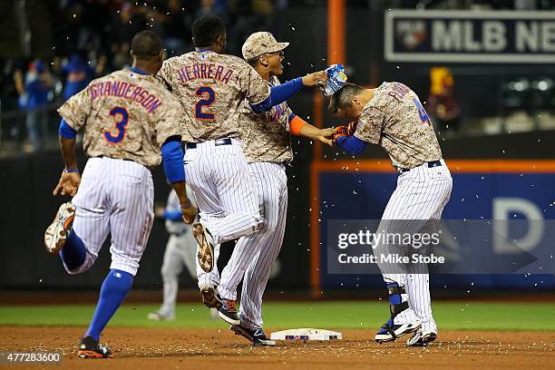 Wilmer Flores of the New York Mets celebrates with his teamates after hitting the game winning single in the eleventh inning against the Toronto Blue...