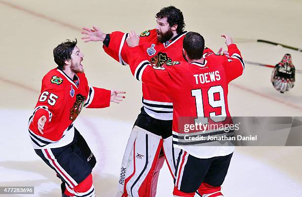 Corey Crawford of the Chicago Blackhawks celebrates with teammates Andrew Shaw and Jonathan Toews after defeating the Tampa Bay Lightning by a score...