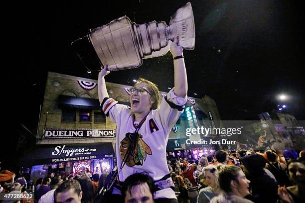 Fans celebrate the Chicago Blackhawks winning the 2015 Stanley Cup in front of at Sluggers World Class Sports Bar on June 15, 2015 in Chicago,...