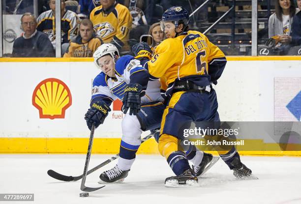 Michael Del Zotto of the Nashville Predators battles against Vladimir Tarasenko of the St. Louis Blues at Bridgestone Arena on March 6, 2014 in...