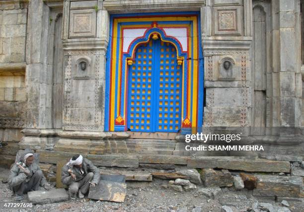 In this photograph taken on June 14 Indian labourers work at the partially restored Kedarnath Temple in the northern state of Uttarakhand, nearly two...