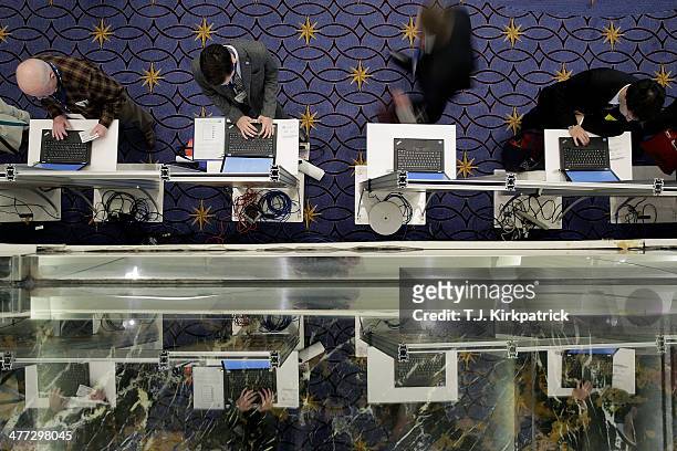 Attendees stand at computers to cast their vote in the presidential straw poll during the 41st annual Conservative Political Action Conference at the...