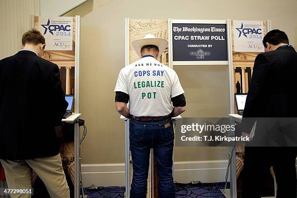 Attendees stand at computers to cast their vote in the presidential straw poll during the 41st annual Conservative Political Action Conference at the...