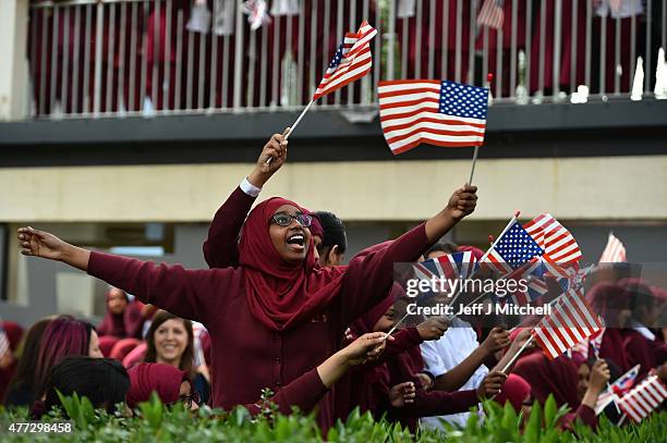 Young women wave the American flag in the courtyard of the Mulberry School for Girls as they await the arrival of US First Lady Michelle Obama for an...