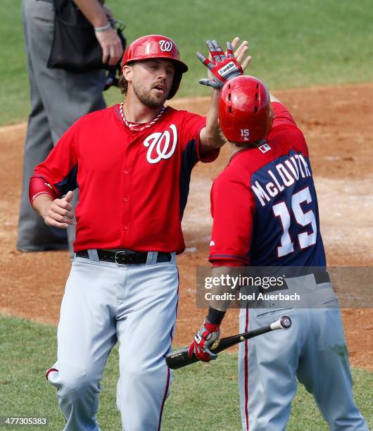 Brock Peterson is congratulated by Nate McLouth of the Washington Nationals after scoring against the St Louis Cardinals in the third inning during a...