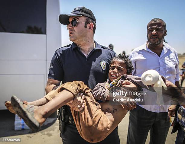 Turkish soldiers carries a wounded Syrian boy who was waiting at the Akcakale Border Gate on his arms in Sanliurfa, Turkey on June 16, 2015. Hundreds...