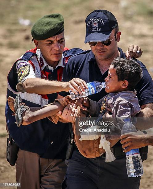 Turkish soldiers gives water to a wounded Syrian boy who was waiting at the Akcakale Border Gate in Sanliurfa, Turkey on June 16, 2015. Hundreds of...