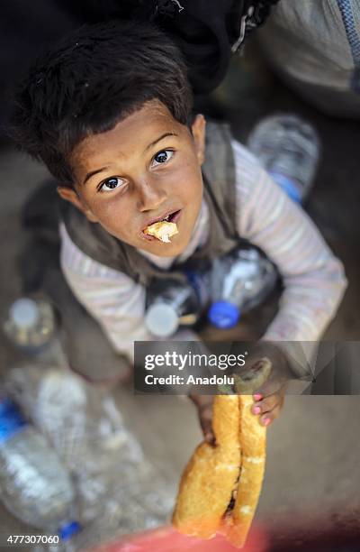 Syrian boy eats food after crossing into Turkey from Akcakale Border Gate in Sanliurfa, Turkey on June 16, 2015. Hundreds of Syrians, fled from...
