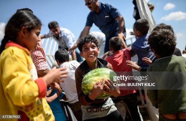 Syrian child holds a watermelon after they were distibuted near the Akcakale crossing gate between Turkey and Syria at Akcakale in Sanliurfa province...
