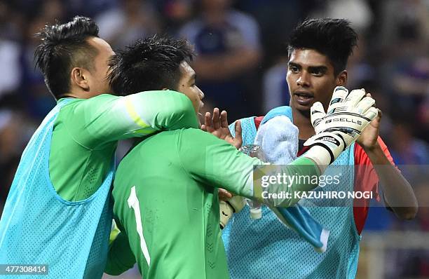 Singapore's goalkeeper Mohamad Izwan Bin Mahbud is congratulated by his teammates following the 2018 FIFA World Cup football qualifying match between...