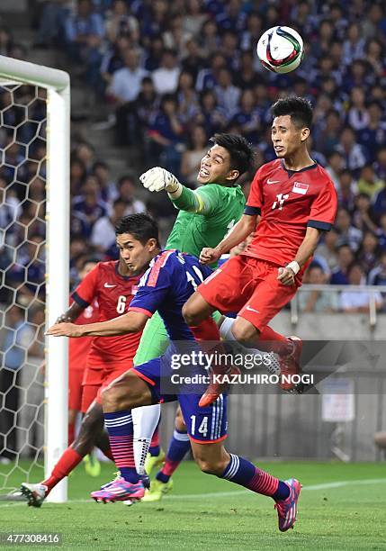 Singapore's goalkeeper Mohamad Izwan Bin Mahbud and his teammate defender Muhammad Nazrul Bin Ahmad Nazari fight for the ball against Japan's forward...