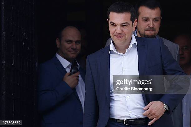 Alexis Tsipras, Greece's prime minister, center, and Nikos Pappas, Greek minister of state, right, leave Maximos Mansion to attend a meeting of the...