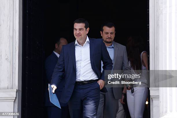 Alexis Tsipras, Greece's prime minister, center, and Nikos Pappas, Greek minister of state, right, leave Maximos Mansion to attend a meeting of the...