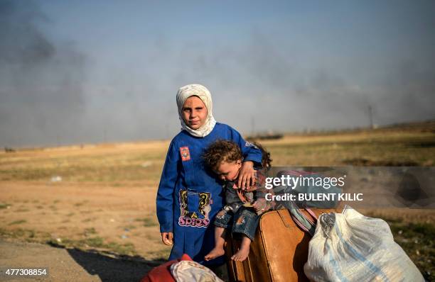 Syrians children wait after entering in Turkey at the Akcakale crossing gate between Turkey and Syria at Akcakale in Sanliurfa province on June 16,...