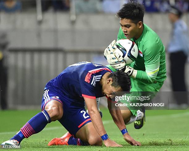 Singapore's goalkeeper Mohamad Izwan Bin Mahbud catches the ball against Japan's defender Tomoaki Makino during the 2018 FIFA World Cup football...