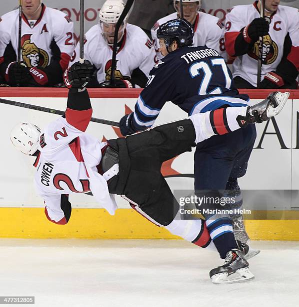 Jared Cowen of the Ottawa Senators is taken down by Eric Tangradi of the Winnipeg Jets in first period action in an NHL game at the MTS Centre on...