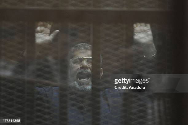 Egyptian former President Mohamed Morsi stands behind the bars during his trial in Cairo on June 16, 2015. An Egyptian court on Tuesday sentenced...