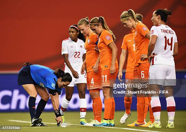Referee Ri Hyang Ok sprays disappearing spray during the FIFA Women's World Cup Group A match between Netherlands and Canada at Olympic Stadium on...