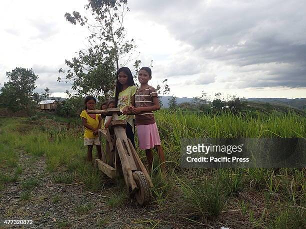 Young girls playing and enjoying a wooden bicycle on the rough roads of Sitio Lumangking in Dumingag, Zamboanga del Sur which is considered as 'World...