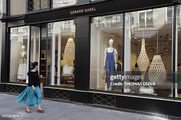 Woman passes in front of a Gerard Darel store, in Paris on June 16, 2015. The French brand of prenium ready-made clothes was placed in receivership...