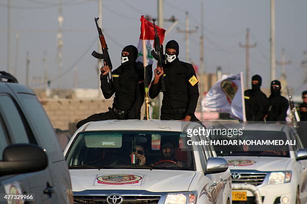 Fighters of the Ansar Allah al-Awfiya Shiite group parade with their weapons on June 16, 2015 in the southern Iraqi city of Basra during celebrations...