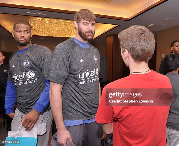 Athletes DeMarcus Cousins and Aaron Gray of The Sacramento Kings greet a student from The United Nations International School at an event recognizing...