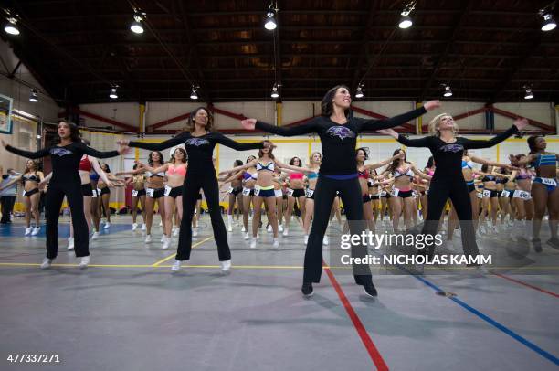 Baltimore Ravens cheerleader lead aspiring cheerleaders through their routine during the first day of the Baltimore Ravens tryouts at a gym in...