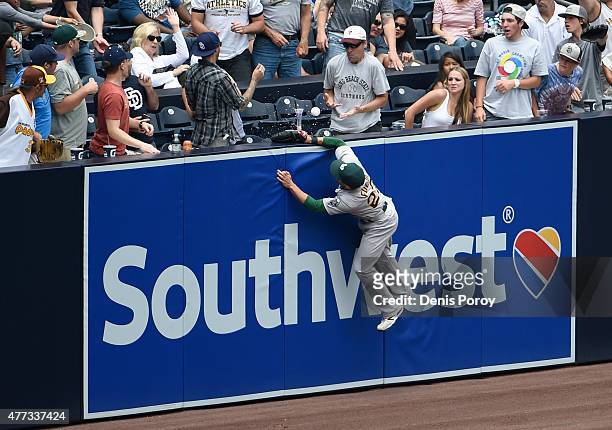 Sam Fuld of the Oakland Athletics climbs the wall but can't make the catch on a home run hit by Austin Hedges of the San Diego Padres during the...