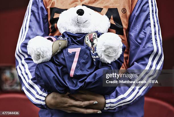 Saki Kumagai of Japan holds a bear wearing a shirt in honour of Kozue Ando, after she broke her leg in an earlier match ahead of the FIFA Women's...