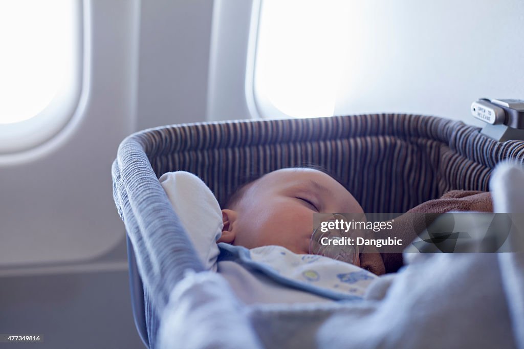 Baby Boy Sleeping In Bassinet On Airplane