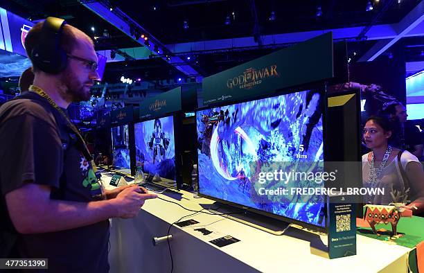 Gaming fans play Playstation's God of War Remastered at E3 - the Electronic Entertainment Expo - an annual video game conference and show at the Los...