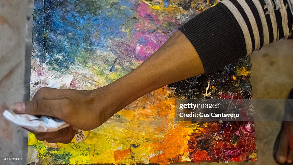 A painter adds yellow oil paint to his palette